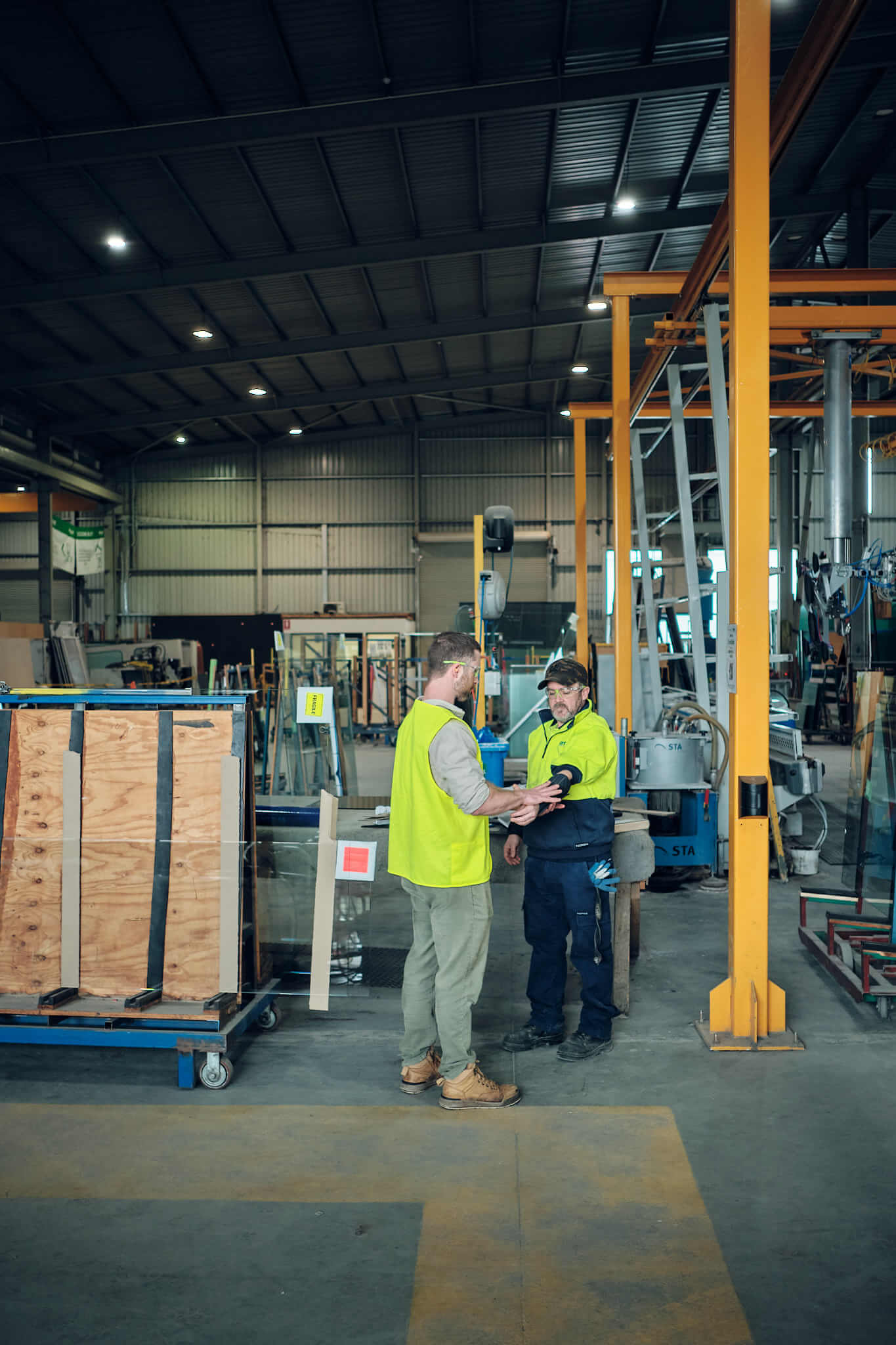 Photo of two men in hi-vis, in an industrial setting